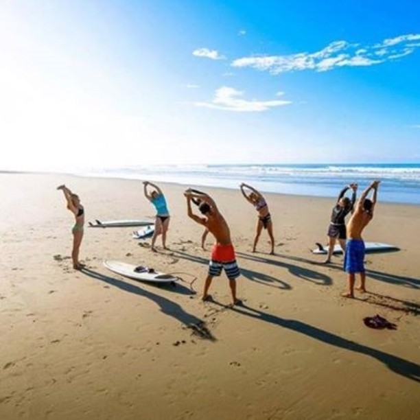 Stretching before surf lessons, Pranamar Oceanfront Villas. Ohoto credit pranamarvillas.