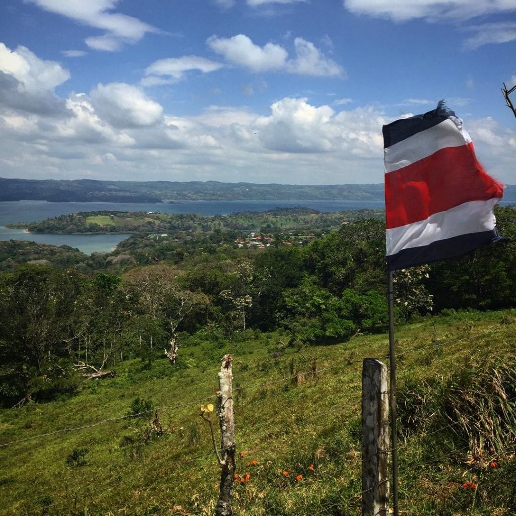 Costa Rican flag waving over Lake Arenal, photo credit @hanka_slavickova